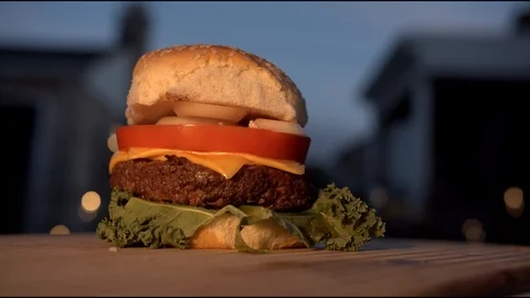Big appetizing burger with meat cutlet, onion, vegetables, melted cheese and Stock Footage 116918767