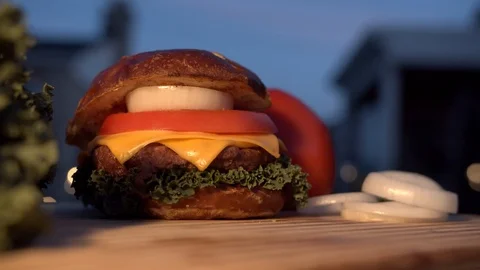 Big appetizing burger with meat cutlet, onion, vegetables, melted cheese and Stock Footage 116922227