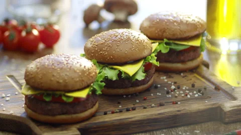 Big appetizing burger with meat cutlet, onion, vegetables, melted cheese Stock Footage 132974742