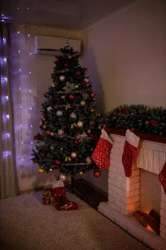 Big artificial New Year tree and home decorated in the evening. Gift boxes an Stock-Fotos