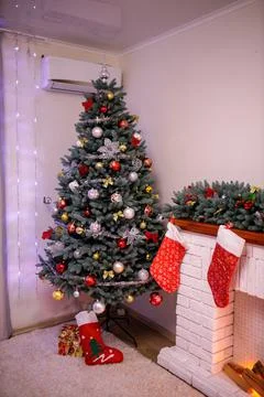 Big artificial New Year tree and home decorated in the evening. Gift boxes an Stock Photos