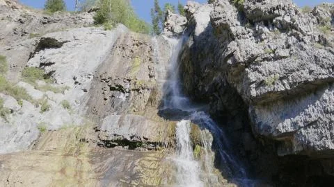Big beautiful waterfall flows down the rocks mountains Stock Photos