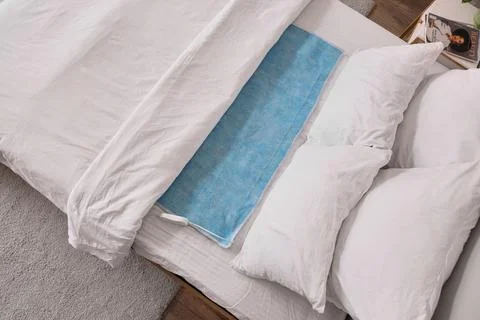 Big bed with electric heating pad in room, top view Stock Photos