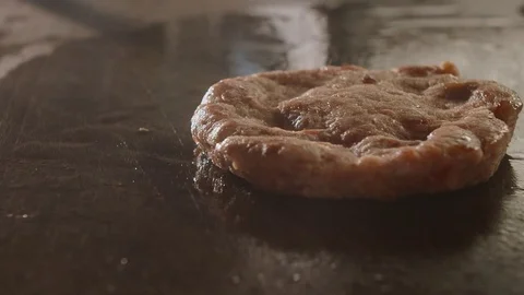 Big beef cutlet is grilled, the chef presses the cutlet with an iron spatula Stock Footage 113866240