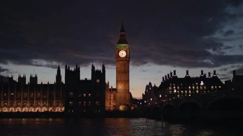Big Ben and Westminster Bridge glow at night as Parliament reflects on the Stock-Footage 317840912