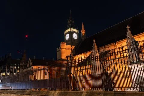 Big Ben clock tower seen from behind iron fencing at night. The layered vie.. Stock-Fotos