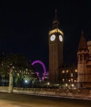 Big Ben clock tower seen from behind iron fencing at night. The layered vie.. Foto stock