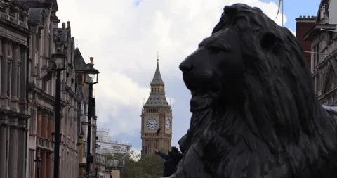 Big Ben framed behind Trafalgar Square lion statue in central London Stock Footage 321019511