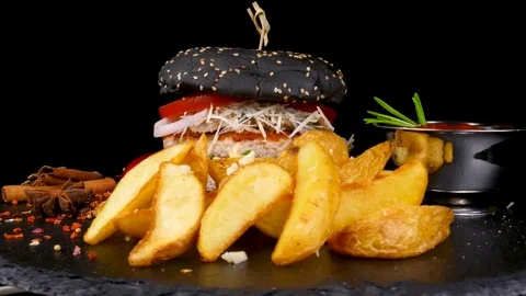 Big black burger with Fried Potato wedges and tomatoes sauce Stock Footage 84652255