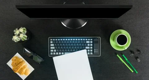 Big black computer screen on a black table with stationary items, working place Stock Photos