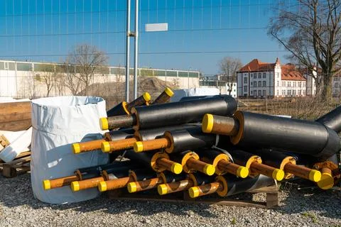 Big black pipe splitters lying on pallets at a construction site. Stock Photos