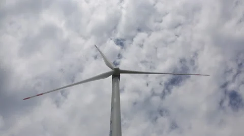 Big blades of a  wind energy generator turn under white clouds Stock Footage 40671092