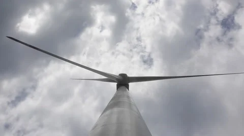 Big blades of a  wind energy generator turn under white clouds Stock Footage 40671099
