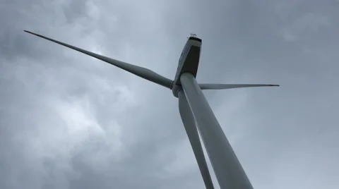 Big blades of a  wind energy generator turn under clouds Stock Footage 40671113