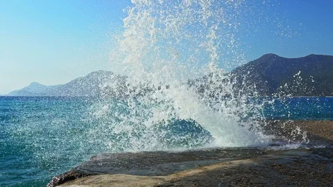 Big blue waves break on the rocky shore. The wave breaks on the shore. Stock Footage 115448648