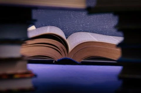 Big book on the table through a stack of books with a place for text, writer  Stock Photos