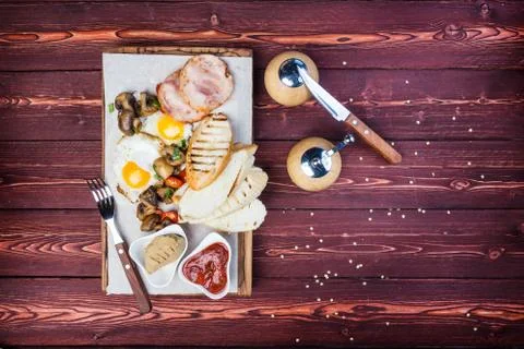 Big breakfast. Ham, bread toast, fried eggs, grilled mushrooms and tomatoes with Stock Photos
