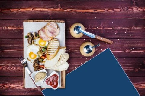 Big breakfast. Ham, bread toast, fried eggs, grilled mushrooms and tomatoes with Foto stock