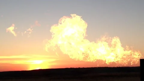 Big bright fire flame leaps upward, setting sun at horizon left side Stock Footage 265491368