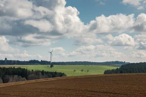 Big brown fields of fertile soil, green forest and wind power in the backgrou Stock-Fotos