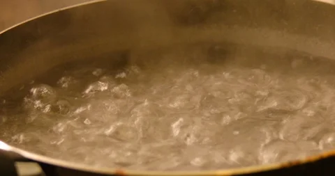 Big bubbles of boiling water with steam over Stock Footage 118298281
