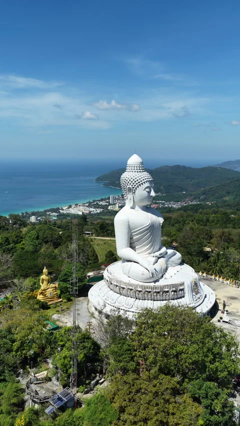 Big Buddha of Phuket above forested hills under clear blue sky Stock Footage 345267676