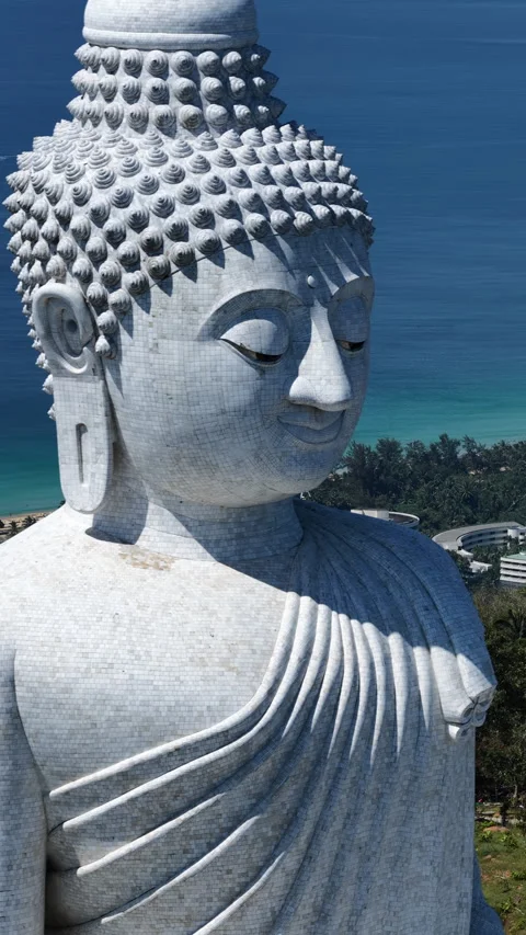 Big Buddha of Phuket face and robes with blue Andaman Sea behind Stock Footage 345264828