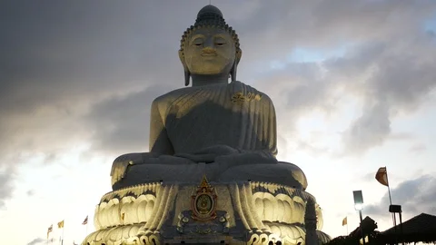 Big buddha statue on hilltop with moving flag in evening time Stock-Footage 99166103
