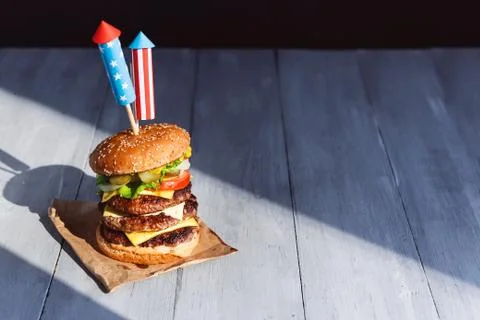A big burger with three juicy beef patties bonded with American flag firework Stock Photos
