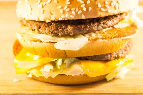 Big burger with two cutlets, cheese and salad. Side view 스톡 사진