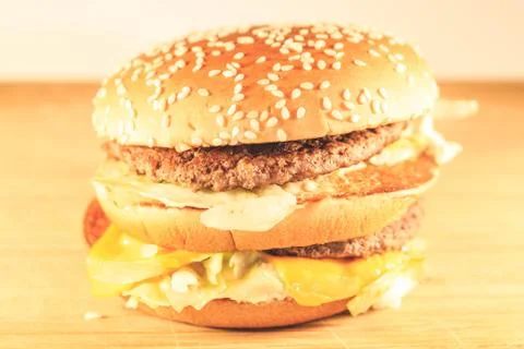 Big burger with two cutlets, cheese and salad. Side view Stockfoto's