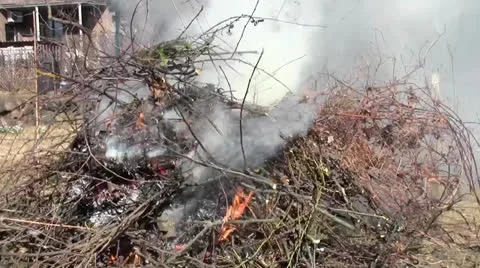 Big burning bonfire made of brances and leaves with much smoke Stock Footage 22740967