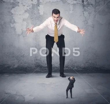 Big business bully looking at small coworker Stock Photos