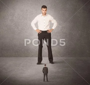 Big business man looking at small worker Stock Photos