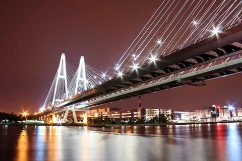 Big cable-stayed bridge over the river at night with colorful bright lighting Stock Photos