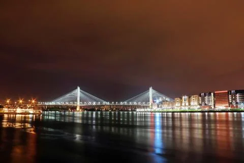 Big cable-stayed bridge over the river at night with colorful bright lighting Stock Photos