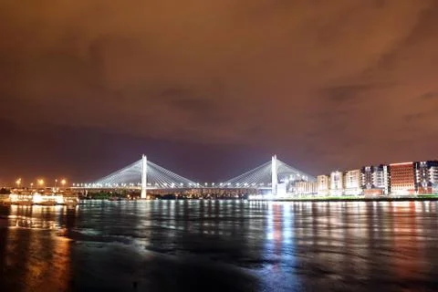 Big cable-stayed bridge over the river at night with colorful bright lighting Stock Photos