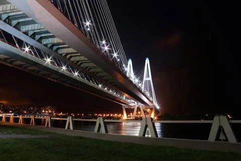 Big cable-stayed bridge over the river at night with colorful bright lighting Stock Photos