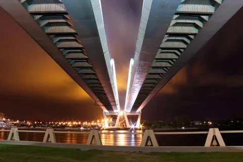 Big cable-stayed bridge over the river at night with colorful bright lighting Stock Photos