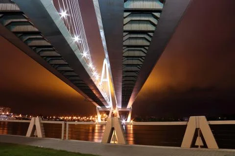 Big cable-stayed bridge over the river at night with colorful bright lighting Stock Photos