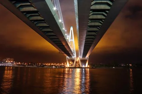 Big cable-stayed bridge over the river at night with colorful bright lighting Stock Photos