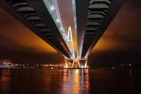Big cable-stayed bridge over the river at night with colorful bright lighting Stock Photos