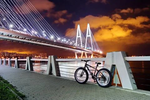 Big cable-stayed bridge over the river at night with colorful bright lighting Stock Photos