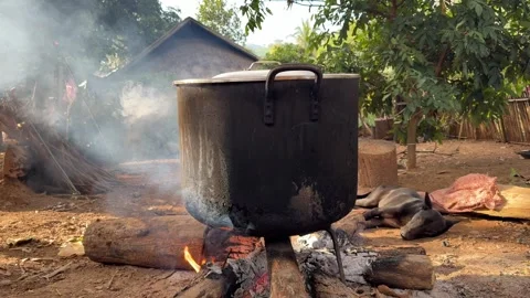 Big cast iron pot boiling water using firewood steaming blowing at rural village Video stock 300749302