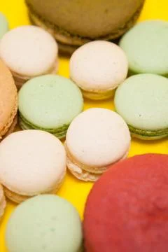 Big cherry macaroon flavour next to different macaroon flavours over yellow Fotos Stock