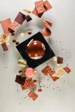 Big chocolate ball surrounded by assorted sweets Stock Photos