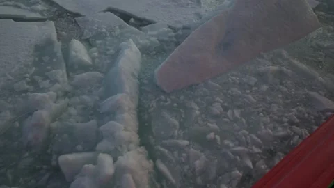 Big chunks of ice outside icebreaker. View from side of vessel back. Sun behind Stock Footage 260471406