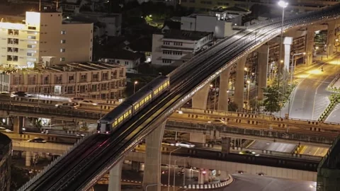 Big city sky train at night on overpass crossroad cars night time Video stock 280699052
