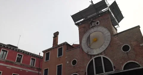 Big clock with sun and roman numbers on dial on catholic church San Giacomo Stock Footage 150387223