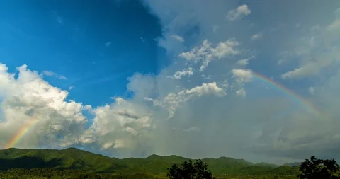 Big clouds and rainbow on sky and mountains Time-lapse Stock Footage 101766931